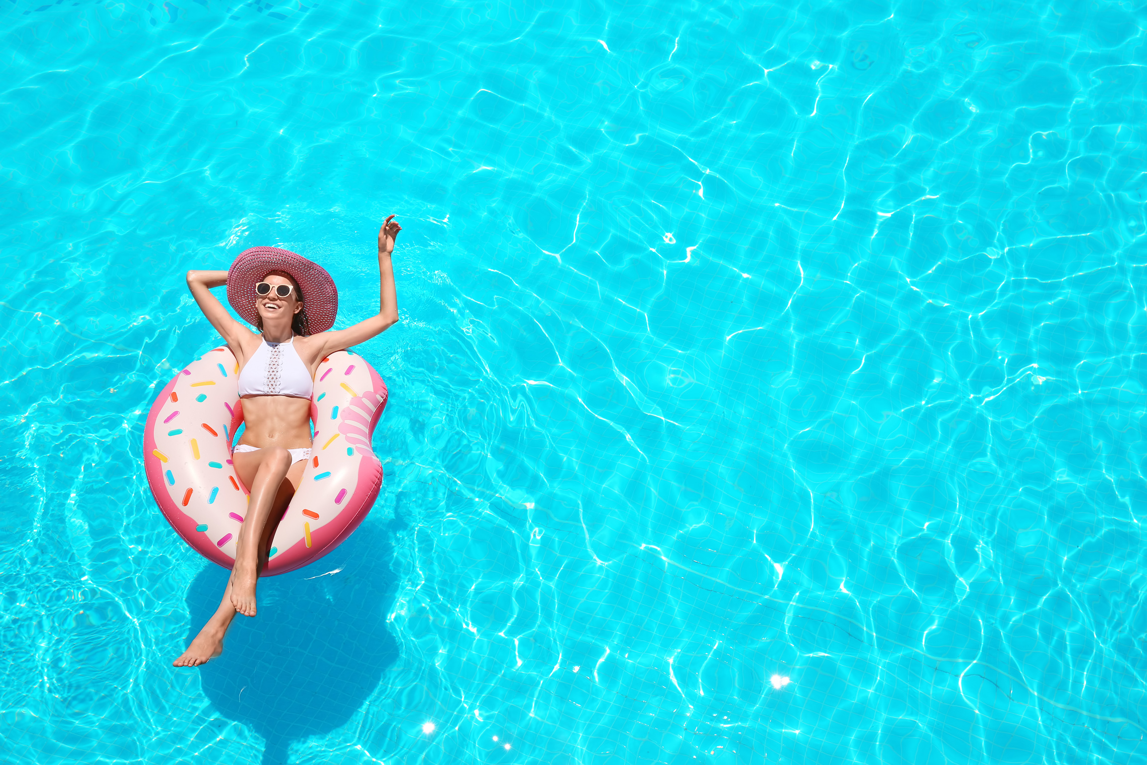 Beautiful Young Woman with Inflatable Donut in Swimming Pool