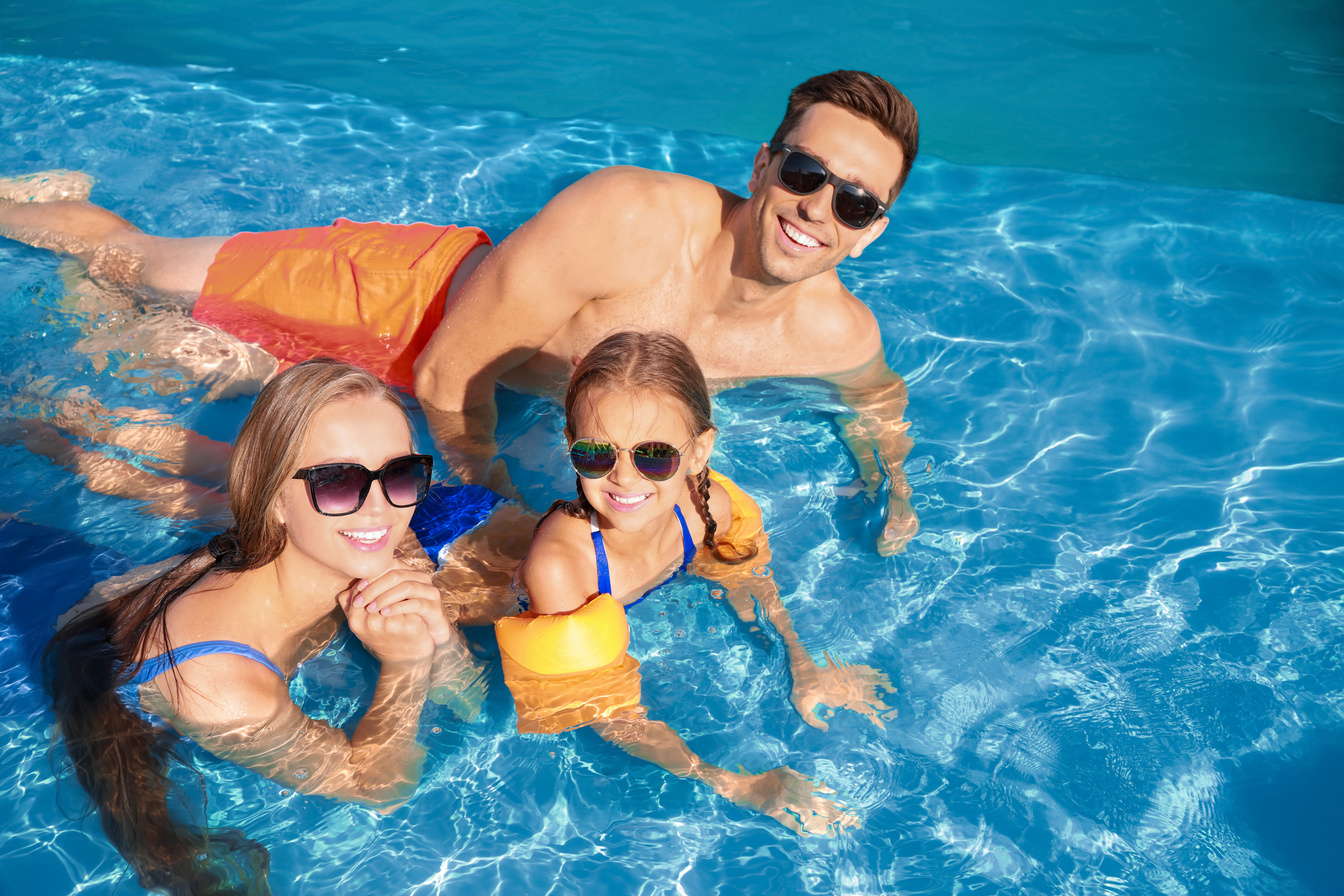 Happy Family in Swimming Pool on Summer Day