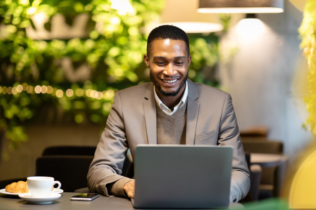 Smiling african american guy using personal computer